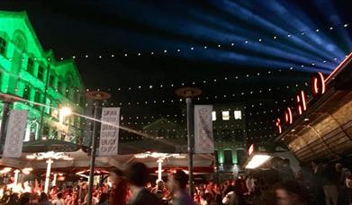 Busy nightlife scene with lasers and festoon lighting