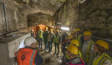 Three people wearing high-vis jackets and smiling.