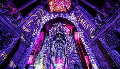 Inside Liverpool Cathedral with lights projecting onto the walls.