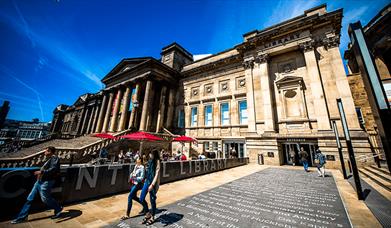 Outside of Liverpool Central Library featuring the tiled floor with the names of famous books on.