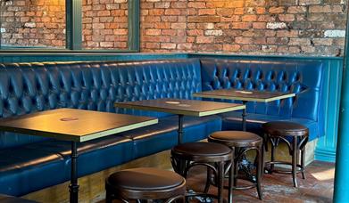 Blue booths and brown chairs in pub.
