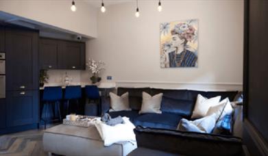 A living room area with a large navy sofa.