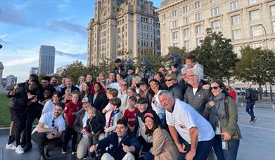 A tour group getting a picture beside The Beatles statues.