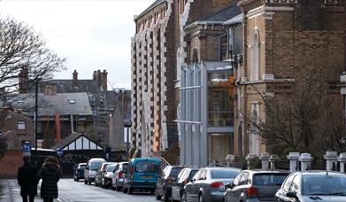 Outside of Unity Theatre with cars parked outside.