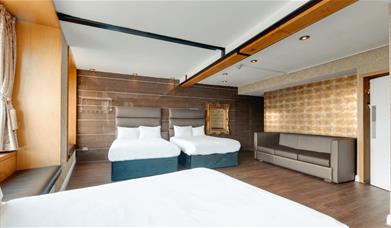 Two plush beds with brown headboards.