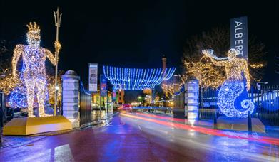 Two large light statues of people at the entrance of Royal Albert Dock.