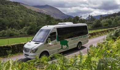 Mountain Goat Tours van driving along a scenic route.