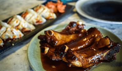 A selection of spicy ribs and dumplings on a plate.