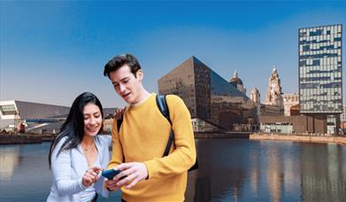 Go Quest Adventures - Liverpool Quest. Two people standing on the dock in Liverpool looking at their mobile phone.