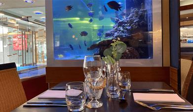 Seven Seas at the Liner Hotel dining table with a fish tank at the centre of the image.