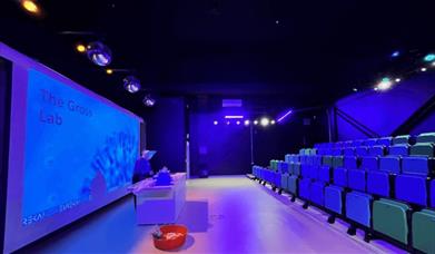 Eureka! Science + Discovery lecture theatre area with purple uplighters.