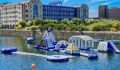 Liverpool Watersports Centre inflatables out in the river. The inflatable assault course features climbing frames which are floating in the river.