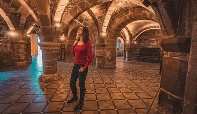 Norton Priory Museum with a person standing looking at the historic walls.